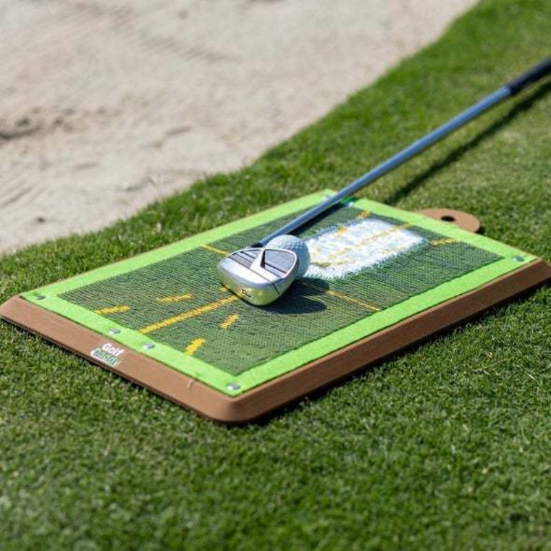 Club de golf reposant sur le tapis de practice