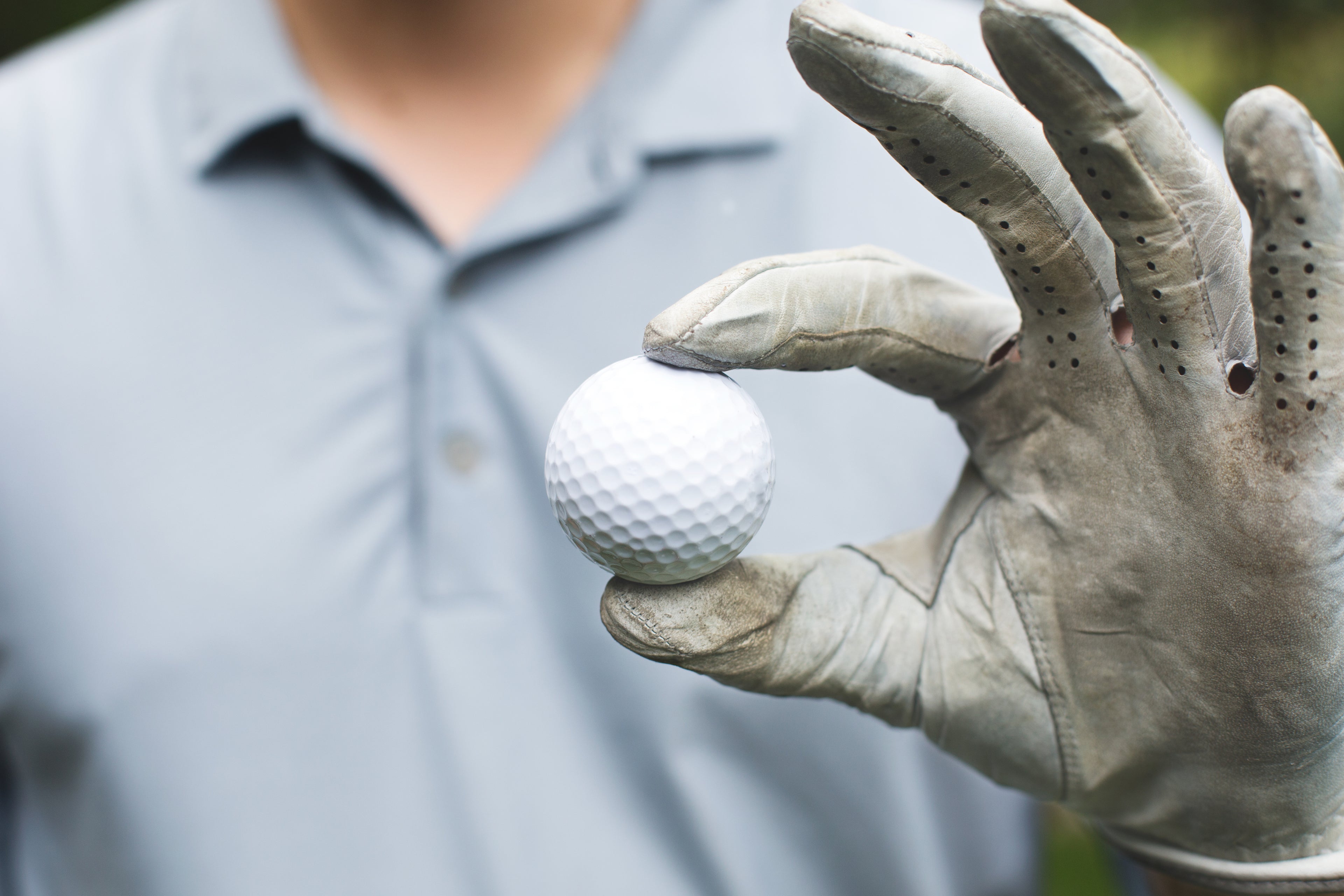 Golfeur tenant une balle de golf -accessoires de golf FitRésolution