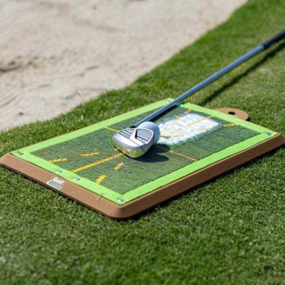 Club de golf reposant sur le tapis de practice