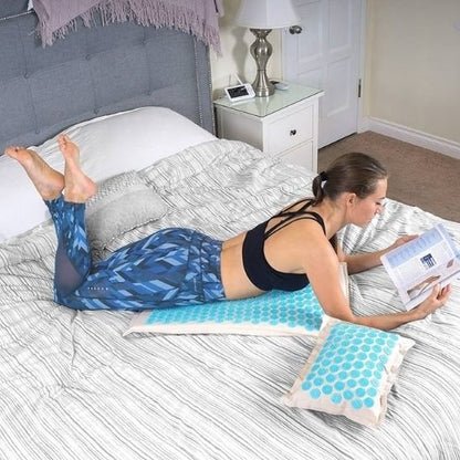 Femme sur le ventre sur son tapis d'acupression